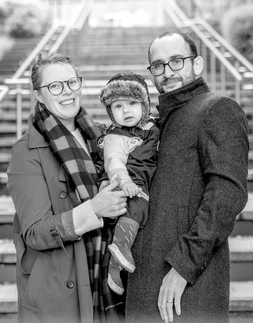 Child smiling with a parent in a black and white outdoor portrait