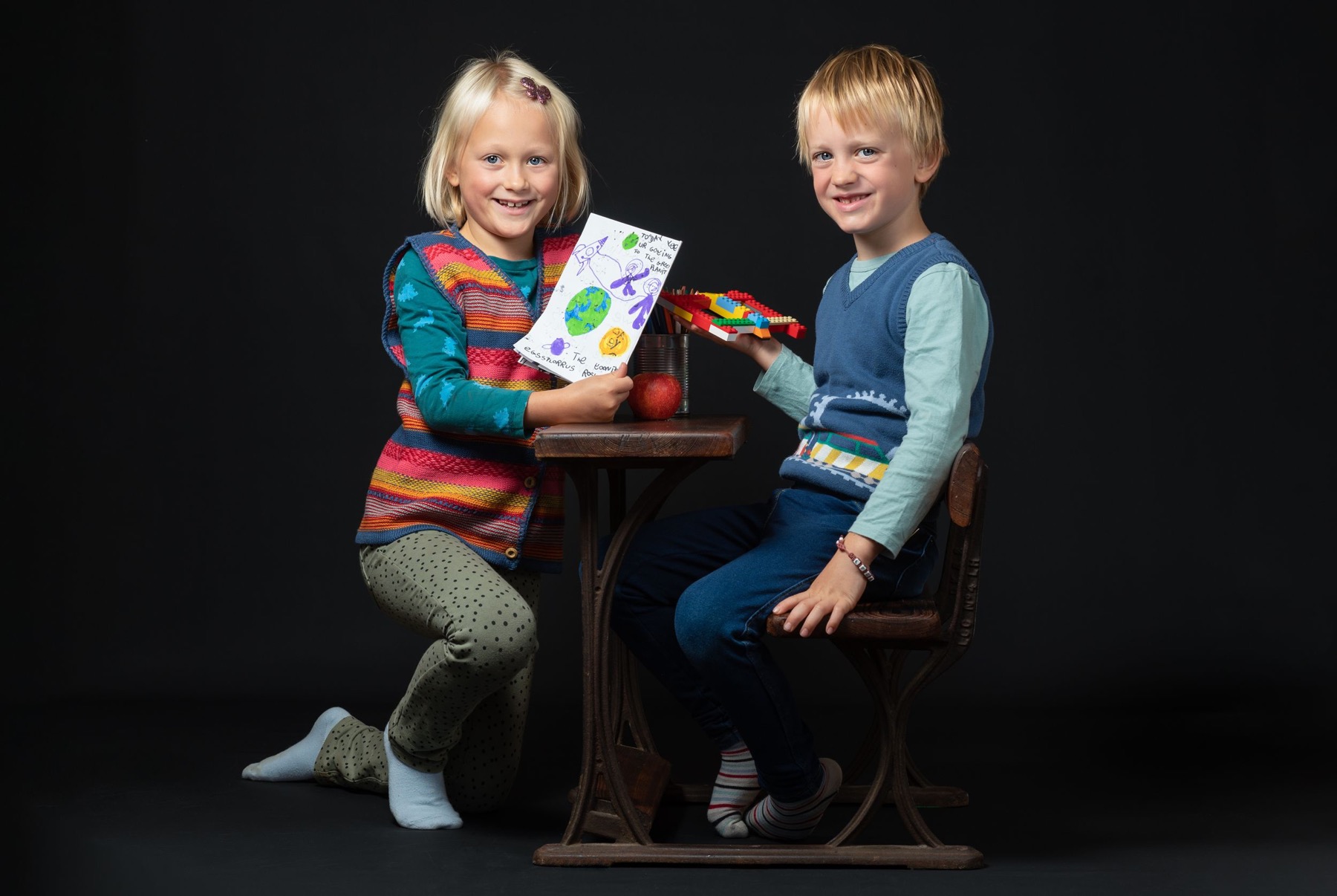Two children smiling in a studio portrait